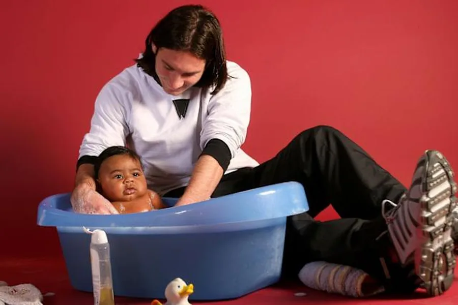 December 2007: a 20-year-old Lionel Messi bathes five-month-old Lamine Yamal during a Barça Foundation and UNICEF charity calendar shoot at Camp Nou